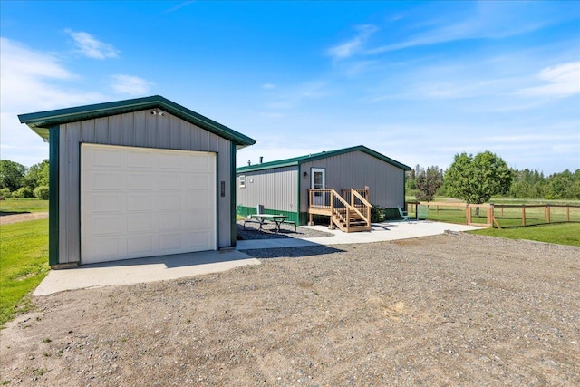 detached garage featuring fence