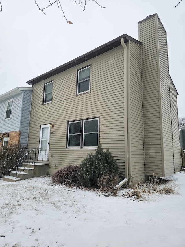 view of snow covered rear of property