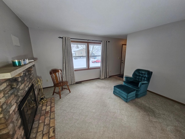 sitting room with a stone fireplace and carpet