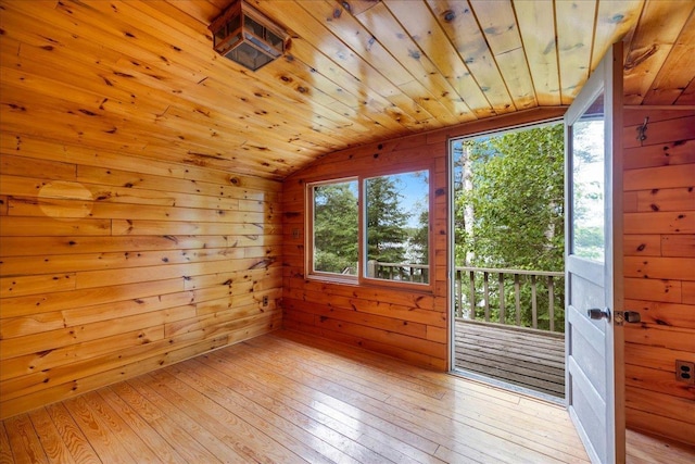 unfurnished room with lofted ceiling, wood ceiling, light hardwood / wood-style floors, and wood walls