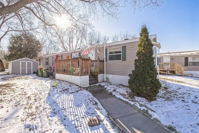 view of front of property featuring a storage shed and a wooden deck