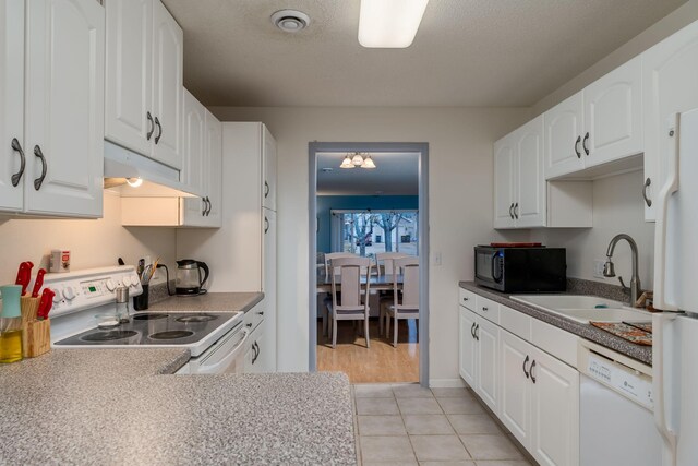 kitchen with under cabinet range hood, white appliances, white cabinetry, and a sink