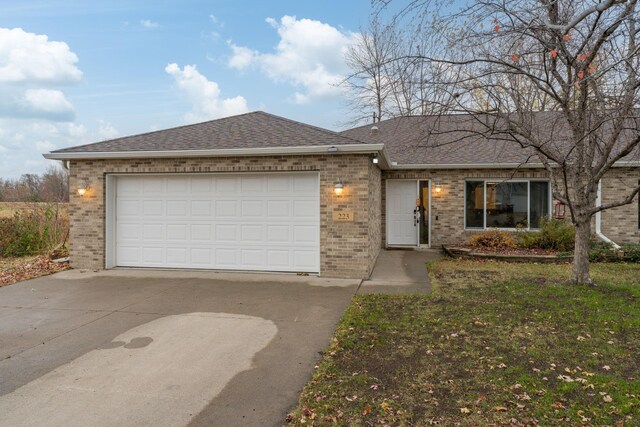 ranch-style home featuring a garage, brick siding, roof with shingles, and driveway