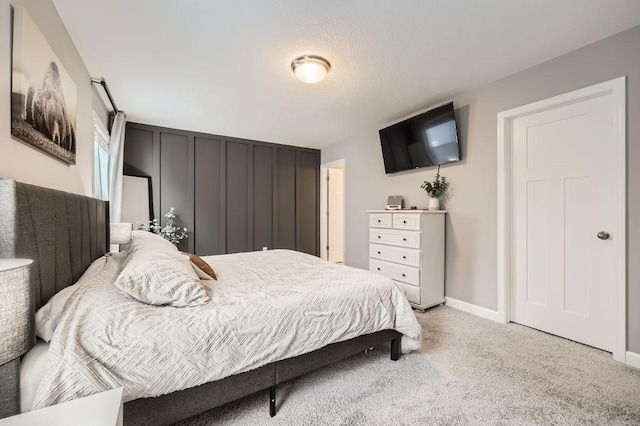 bedroom featuring light carpet and baseboards