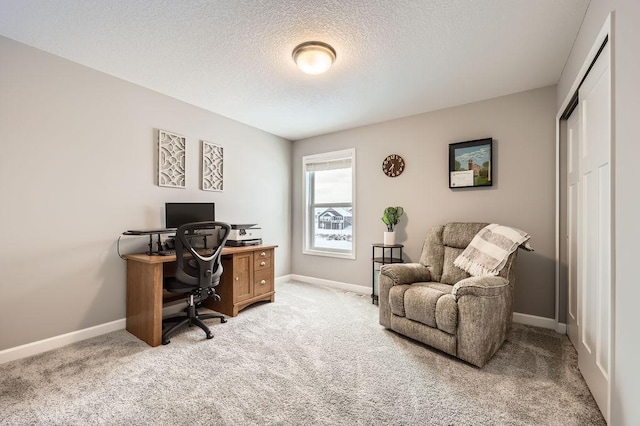 office area featuring light carpet, a textured ceiling, and baseboards