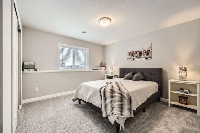 bedroom featuring carpet flooring, a textured ceiling, and baseboards