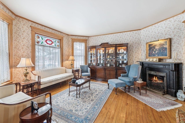 living area with hardwood / wood-style flooring and ornamental molding