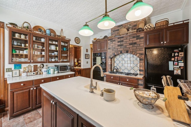 kitchen with decorative light fixtures, ornamental molding, stainless steel appliances, and dark brown cabinets