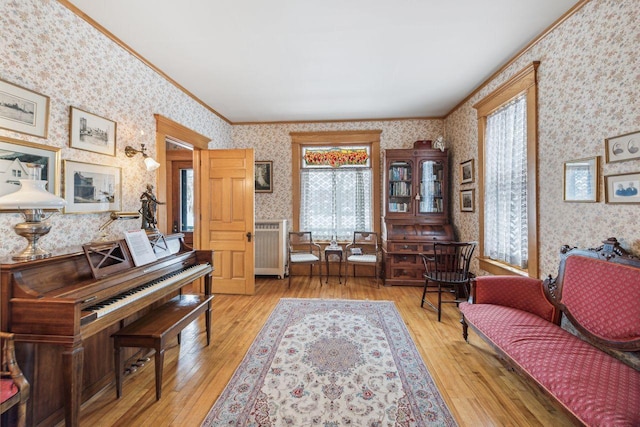 living area featuring light hardwood / wood-style flooring and ornamental molding