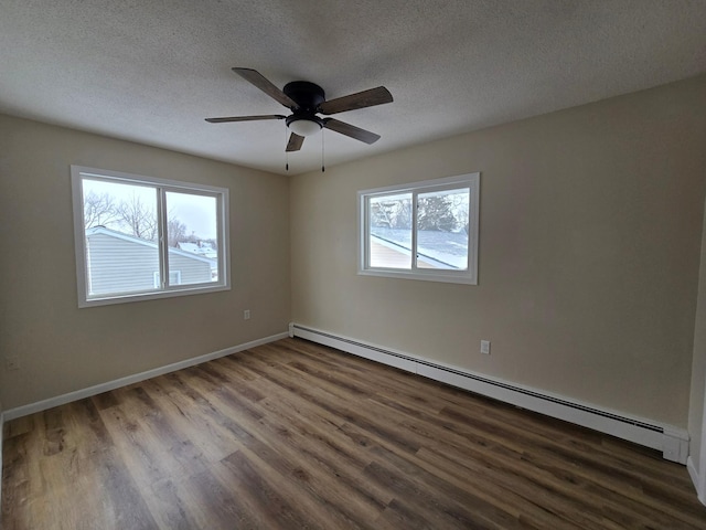 empty room with baseboards, a textured ceiling, a baseboard heating unit, and dark wood-style flooring