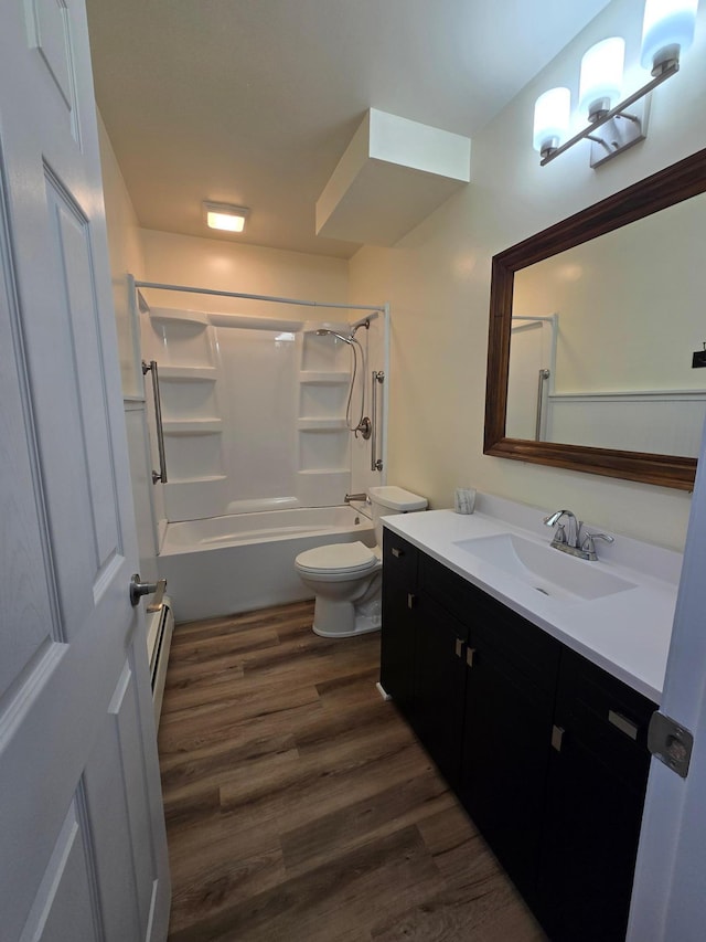 bathroom featuring a baseboard radiator, toilet, wood finished floors, vanity, and washtub / shower combination