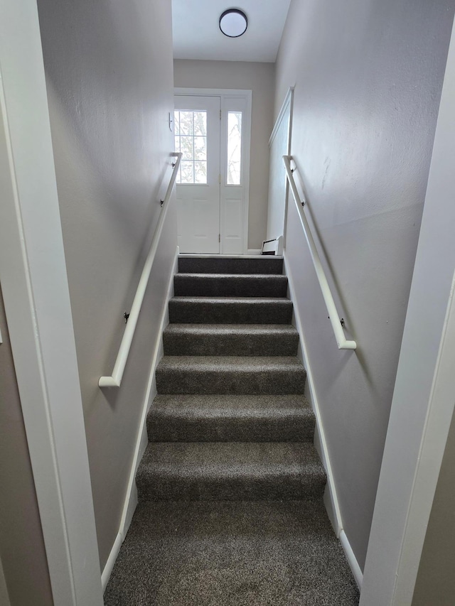 stairs featuring carpet and baseboards