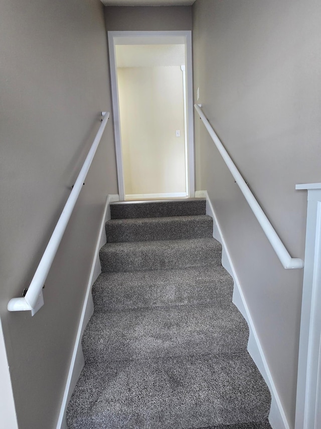 staircase with carpet floors and baseboards