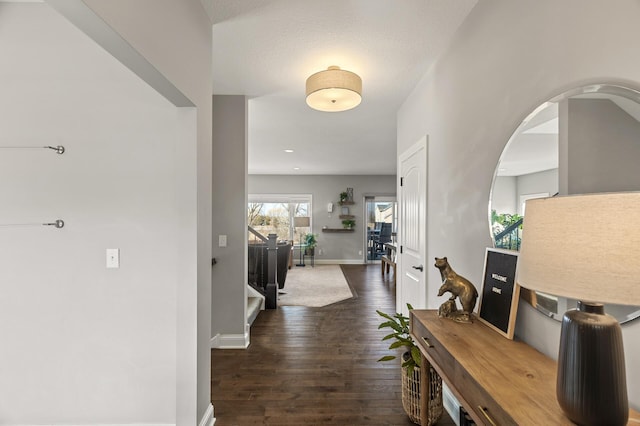 hallway featuring baseboards and wood finished floors