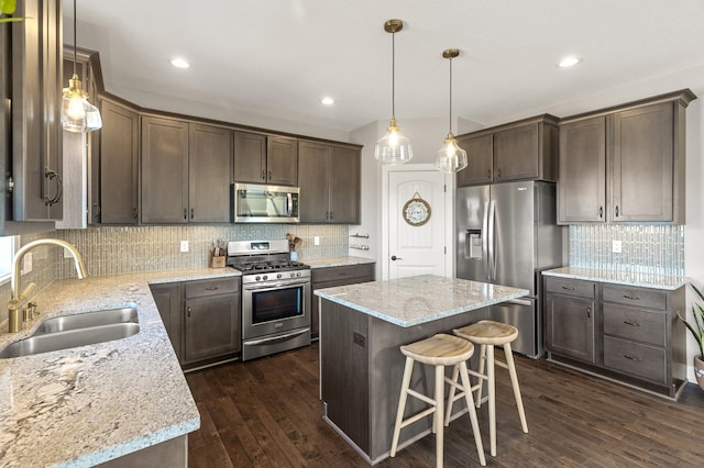 kitchen with a sink, dark brown cabinetry, dark wood-style floors, and stainless steel appliances