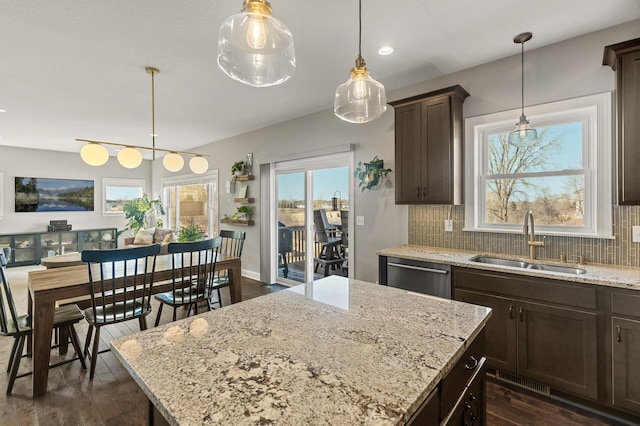 kitchen featuring a sink, tasteful backsplash, stainless steel dishwasher, dark brown cabinets, and dark wood-style flooring