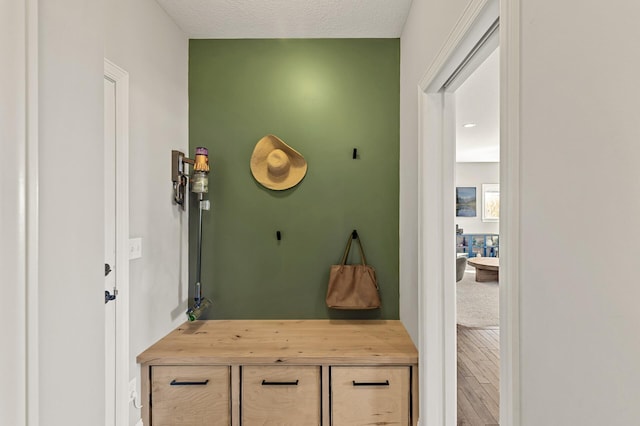 mudroom featuring a textured ceiling and wood finished floors