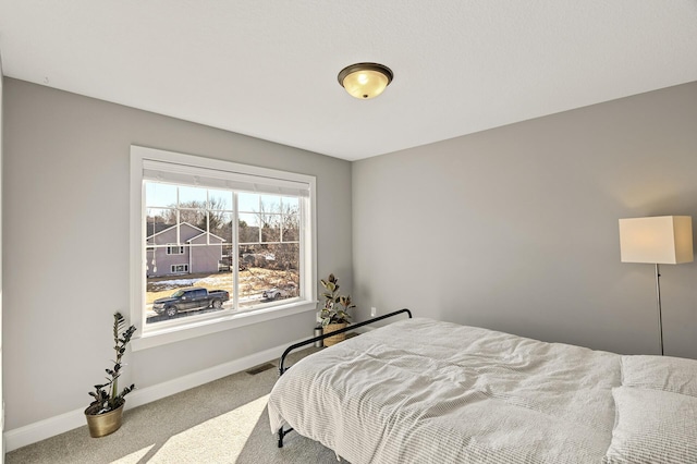 carpeted bedroom featuring visible vents and baseboards