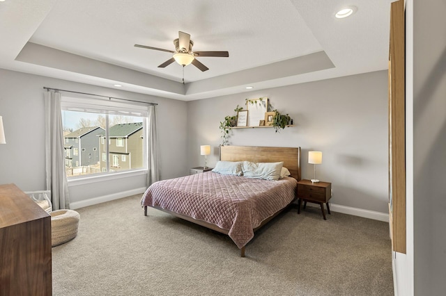 bedroom featuring a tray ceiling, recessed lighting, baseboards, and carpet floors