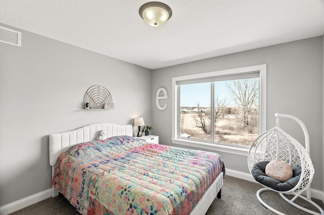 carpeted bedroom featuring visible vents, baseboards, and a textured ceiling