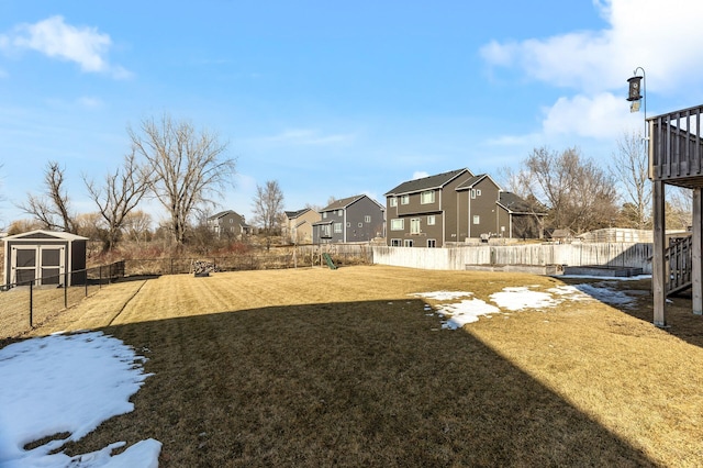 view of yard with a residential view, an outdoor structure, and a fenced backyard