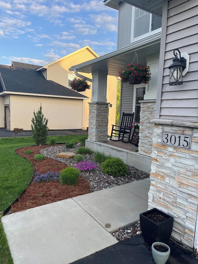 doorway to property featuring stone siding and a porch