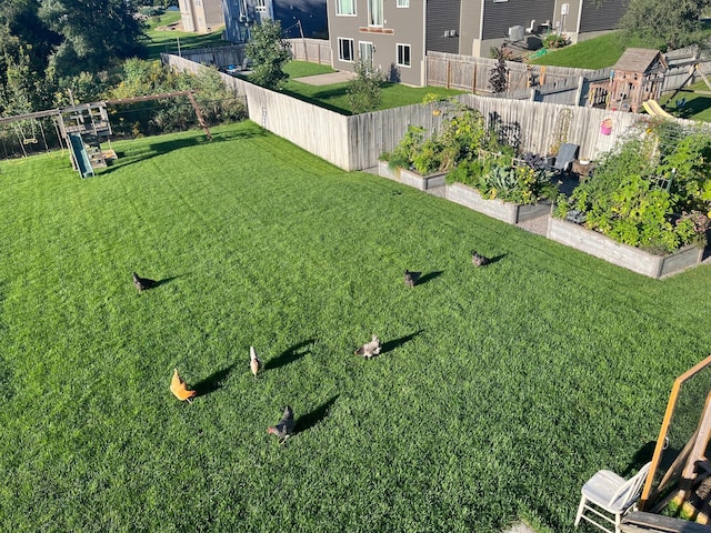 view of yard featuring a garden and a fenced backyard