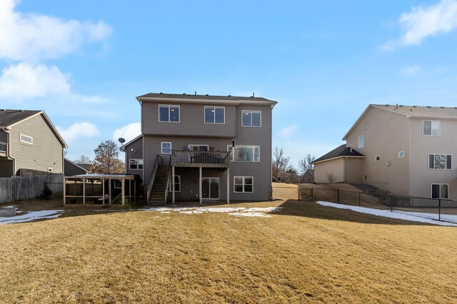 back of property with a deck, stairway, a yard, and a fenced backyard