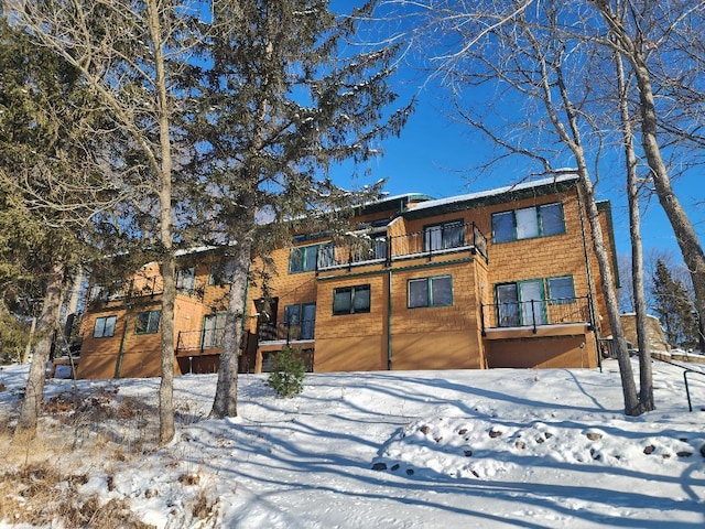 snow covered property featuring a balcony