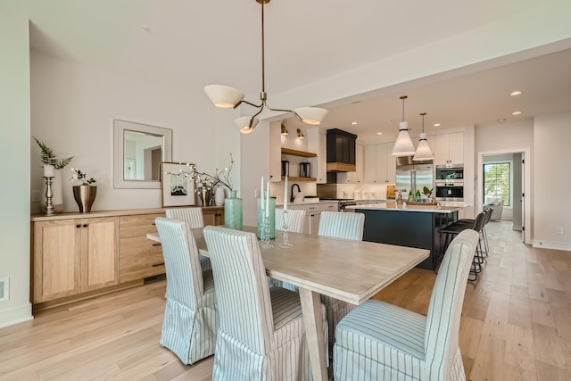 dining space featuring sink and light wood-type flooring