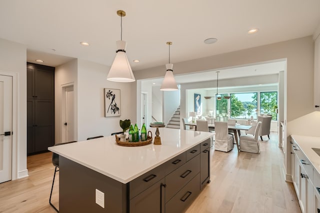 kitchen featuring pendant lighting, light hardwood / wood-style flooring, white cabinets, and a kitchen island