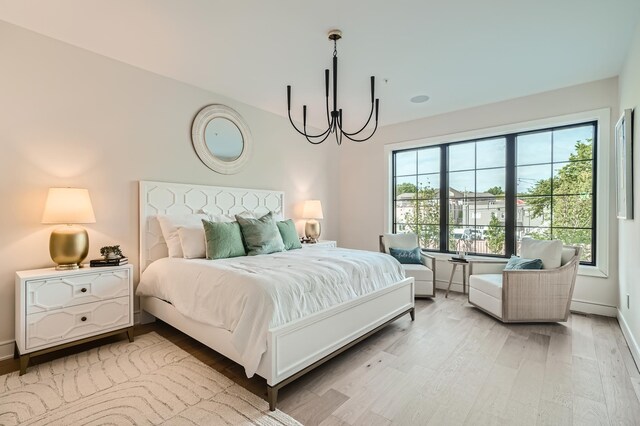 bedroom featuring a chandelier and light hardwood / wood-style flooring