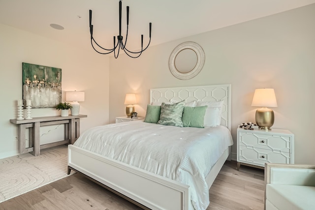 bedroom with an inviting chandelier and light wood-type flooring