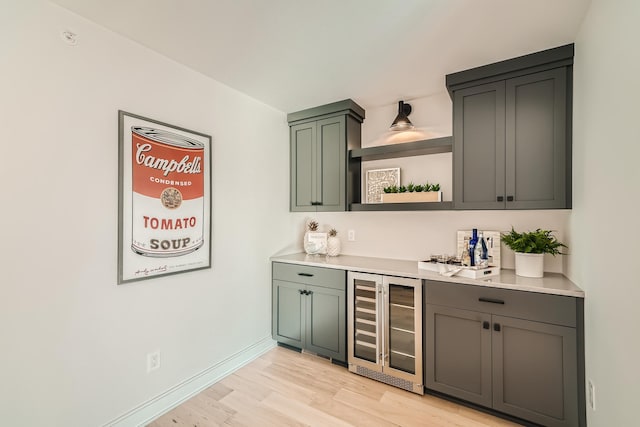 bar featuring wine cooler and light hardwood / wood-style floors