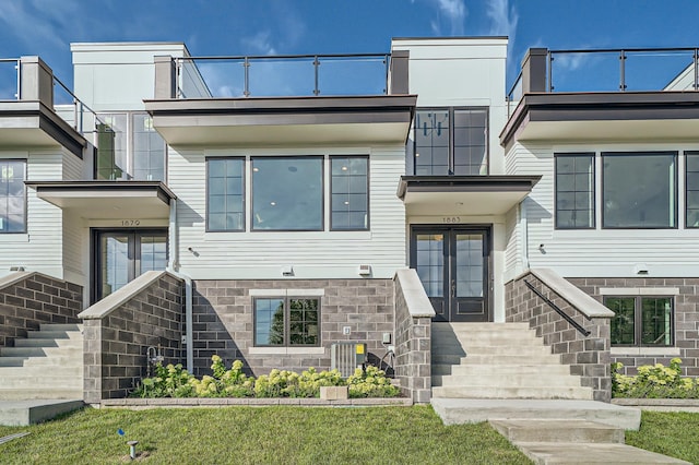 view of front of property with french doors and a front lawn