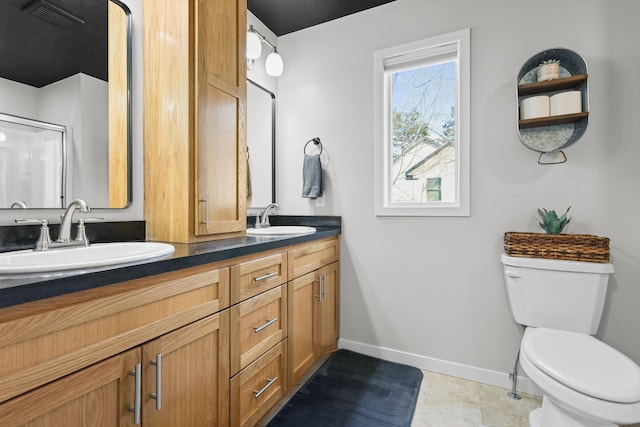 bathroom featuring tile patterned floors, toilet, vanity, and an enclosed shower