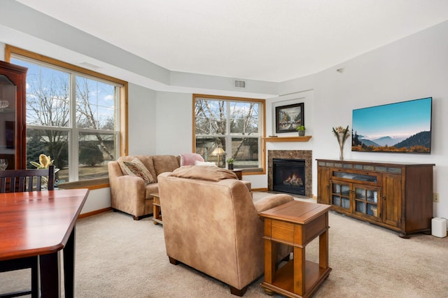 living room with baseboards, visible vents, carpet flooring, and a glass covered fireplace