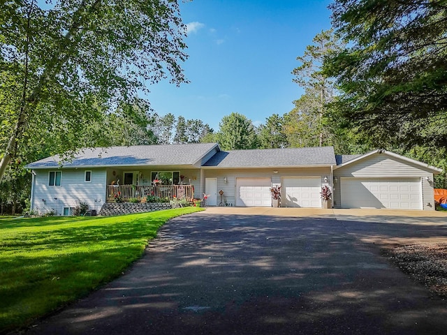 ranch-style home featuring a garage, driveway, a porch, and a front yard