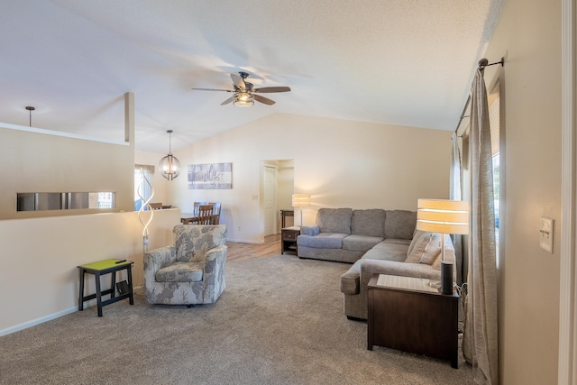 living room with lofted ceiling, baseboards, carpet, and ceiling fan with notable chandelier