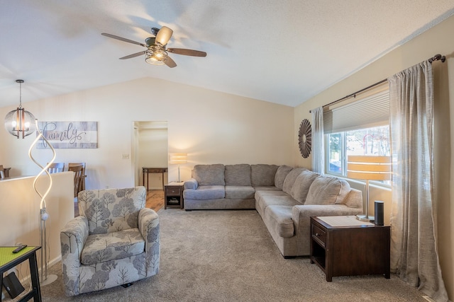 carpeted living room featuring lofted ceiling and ceiling fan with notable chandelier