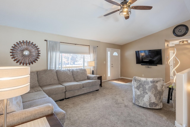 carpeted living area with lofted ceiling, ceiling fan, and baseboards