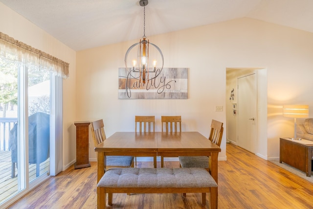 dining space with vaulted ceiling, baseboards, wood finished floors, and a chandelier