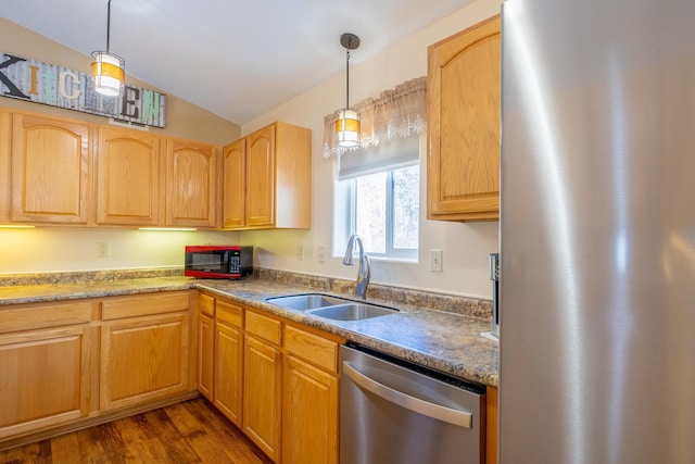 kitchen with stainless steel appliances, lofted ceiling, pendant lighting, and a sink