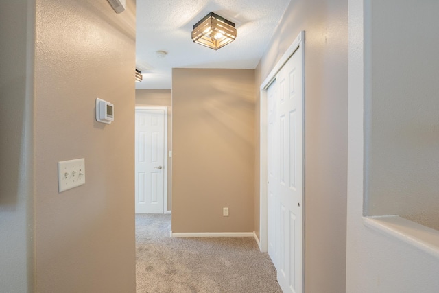 hallway with carpet floors and baseboards