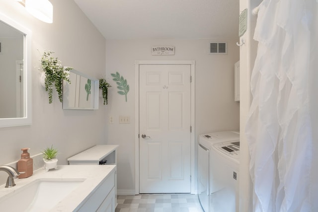 bathroom featuring vanity, visible vents, washer and dryer, and tile patterned floors