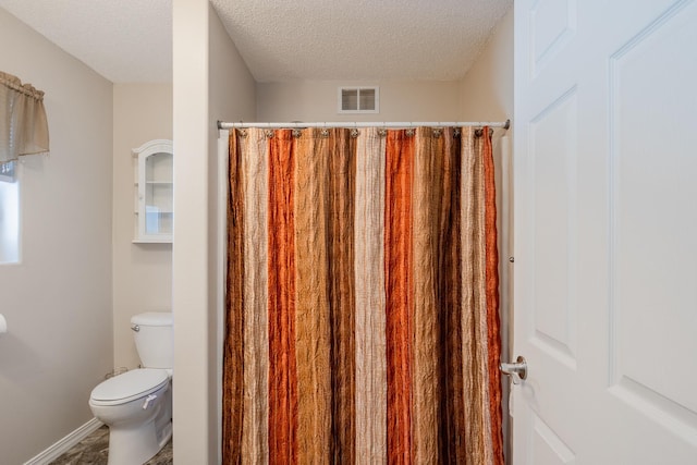 full bathroom featuring baseboards, visible vents, toilet, curtained shower, and a textured ceiling