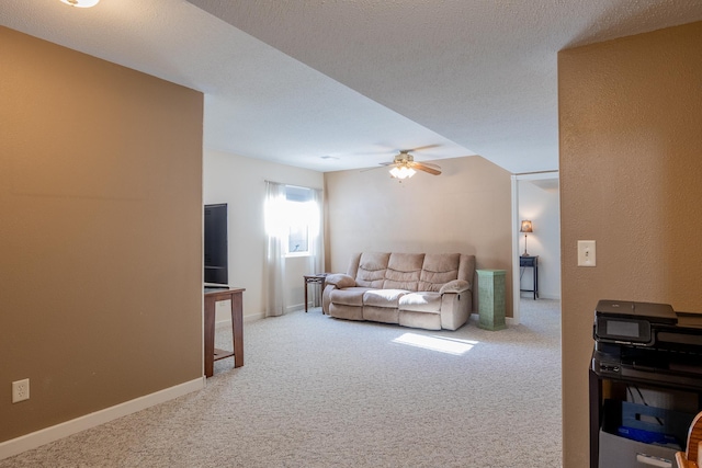 carpeted living room featuring a ceiling fan, a textured ceiling, and baseboards