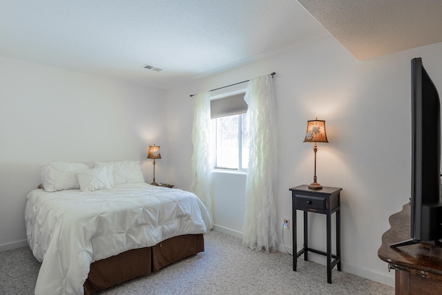 carpeted bedroom with visible vents and baseboards