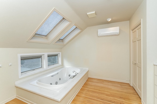 full bath with a whirlpool tub, an AC wall unit, wood finished floors, and lofted ceiling