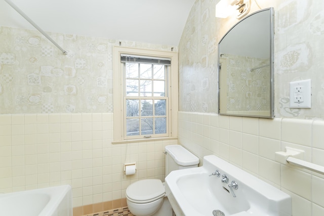 full bath featuring toilet, wainscoting, walk in shower, a bathtub, and wallpapered walls